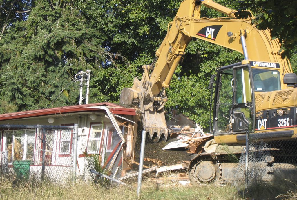 Large machine demolishing old building