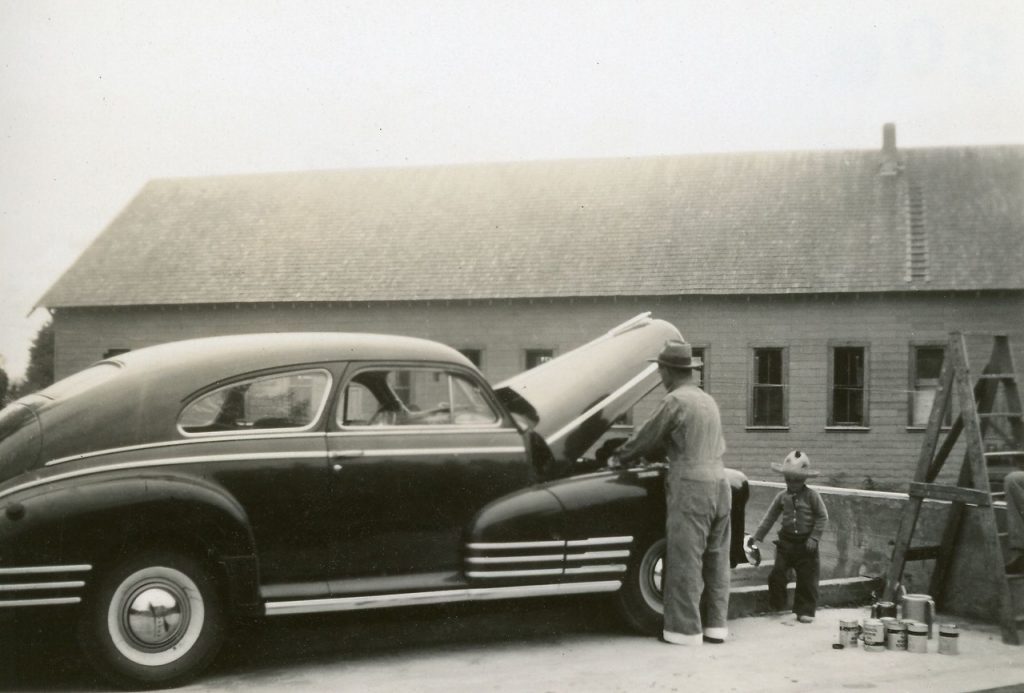 Man and child working oin old automobile